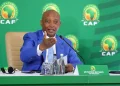 CAN : Patrice Motsepe envisage un retour à une édition tous les deux ans 16 Patrice Motsepe, président de la CAF, assis en train de prendre la parole lors d’une intervention sur le football africain.