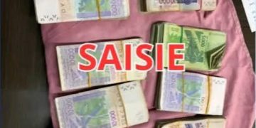 Billets de banque présentés sur un drap, correspondant aux 10 millions de FCFA retrouvés par la police à Bouaké.