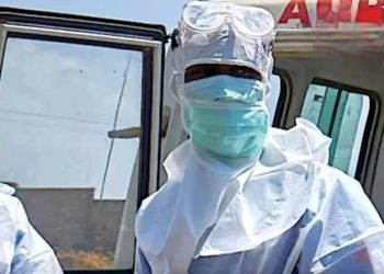 Ebola au Nigeria : un premier cas confirmé à Abuja 2 Personnel de santé portant une combinaison de protection, des lunettes, un masque et des gants dans un environnement médical.